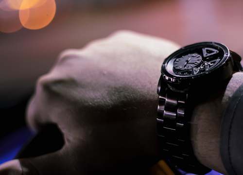 wristwatch selective photo of person holding vehicle steering wheel watch